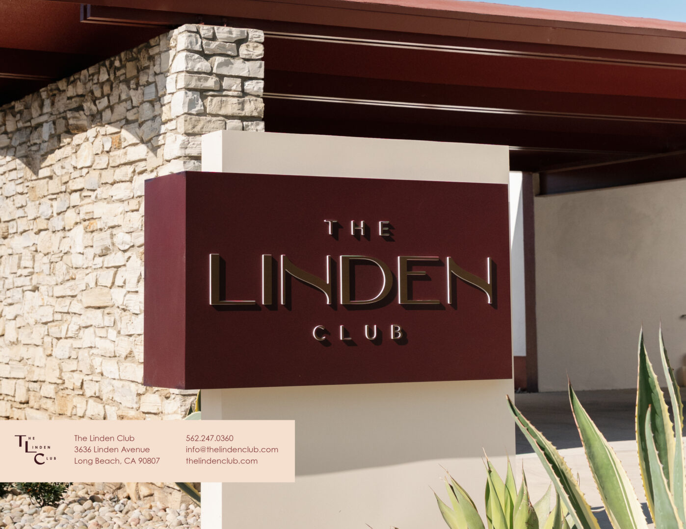 A modern sign reading The Linden Club stands in front of a stone building with a brown roof. There is a partial view of agave plants nearby and contact information for the club in the corner.