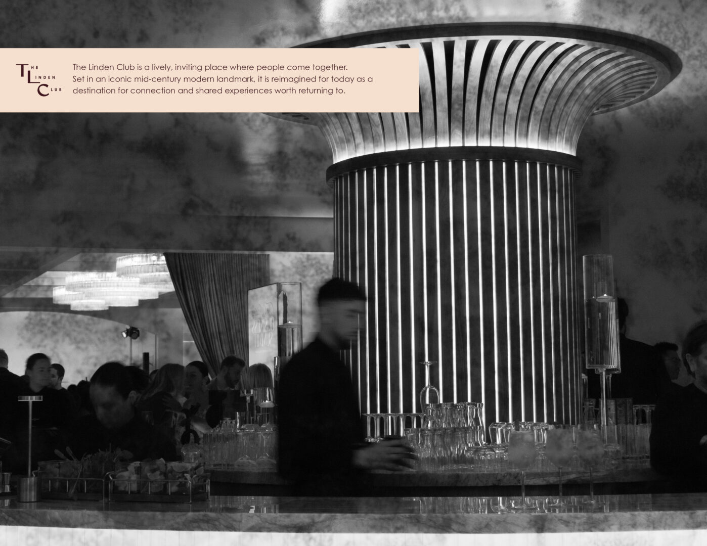 Black and white photo of a stylish, modern bar with a large illuminated column, people mingling, and bartenders working behind the counter. Text about The Linden Club appears in the top left corner.